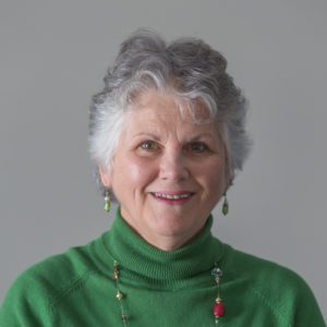 A woman in a green turtleneck exudes confidence with her stylish necklace.